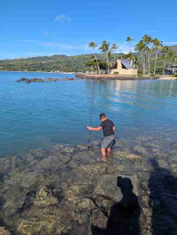 Young Boy Micro Fishing Off a Rock Wall in Hawaii